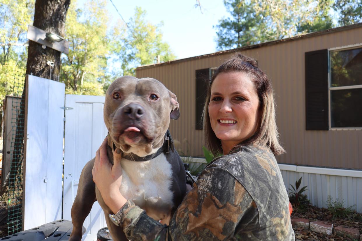 Megan Wiggins holds one of her dogs, Dozer, at her home. The sister of Thomas Coutee Jr., Wiggins mourns her brother while also dealing with the theft of her identity by the woman who killed him. Kayla Giles, her sister-in-law, pleaded guilty in the case after she was convicted in Coutee's murder.