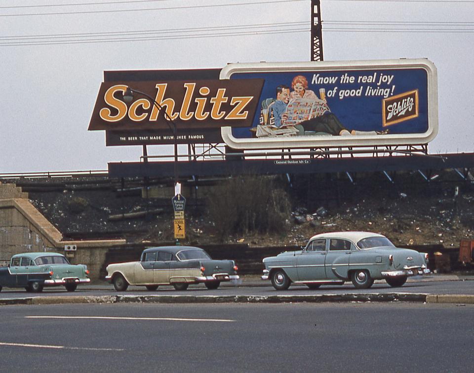 A Schlitz billboard sign above a highway in the 70s