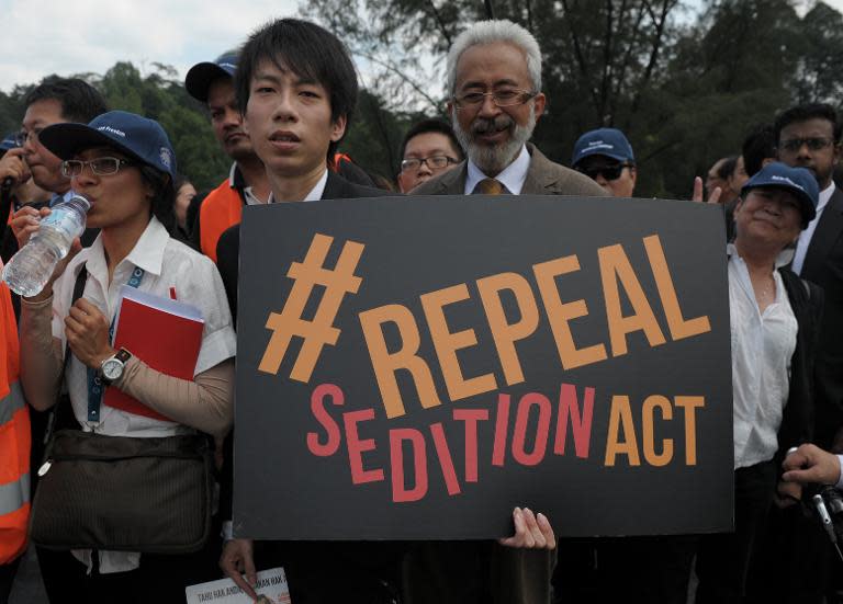 A Malaysian Lawyer holds a placard outside the Parliament house in Kuala Lumpur on October 16, 2014 during a rally to repeal the Sedition Act