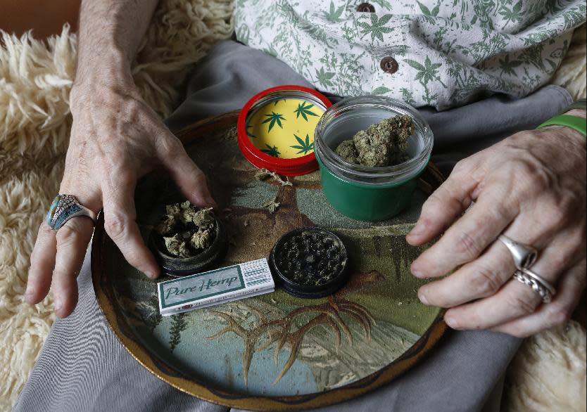 In this April 30, 2014 photo, Bill Britt, who suffers from epileptic seizures and leg pain from a childhood case of polio, prepares a medical marijuana joint at his home in Long Beach, Calif. Britt lives mostly on Social Security income and gets his supply for free from a friend whom he helps water and grow the plants. Insurers are reluctant to cover medical marijuana because of conflicting laws and lack of approval from the U.S. Food and Drug Administration. (AP Photo/Damian Dovarganes)