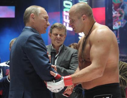 Russian Prime Minister Vladimir Putin (L) shakes hands with Fedor Emelianenko prior to a 2011 fight. (AP)