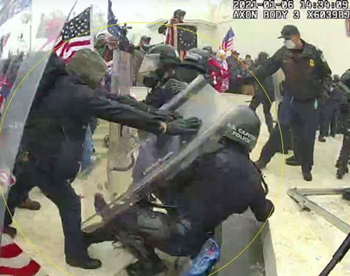 Brian Christopher Mock, left, shoves a Capitol police officer to the ground on Jan. 6, 2021. (U.S. District Court for D.C. )