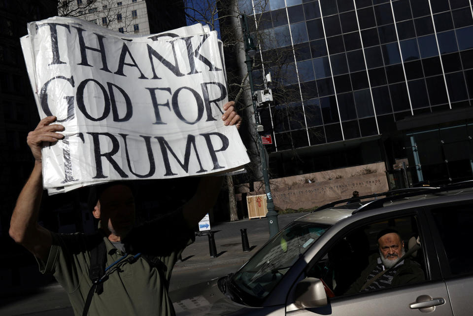 Trump supporter holds up a sign at a protest to support immigration activist Ravi Ragbir