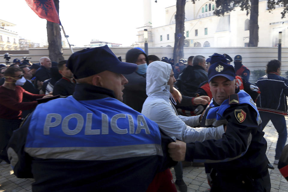 Protesters and police officers push each other during an anti-government rally in Tirana, Albania, Thursday, March 21, 2019. Thousand opposition protesters have gathered in front of Albania's parliament building calling for the government's resignation and an early election. Rally is part of the center-right Democratic Party-led opposition's protests over the last month accusing the leftist Socialist Party government of Prime Minister Edi Rama of being corrupt and linked to organized crime. (AP Photo/ Hektor Pustina)