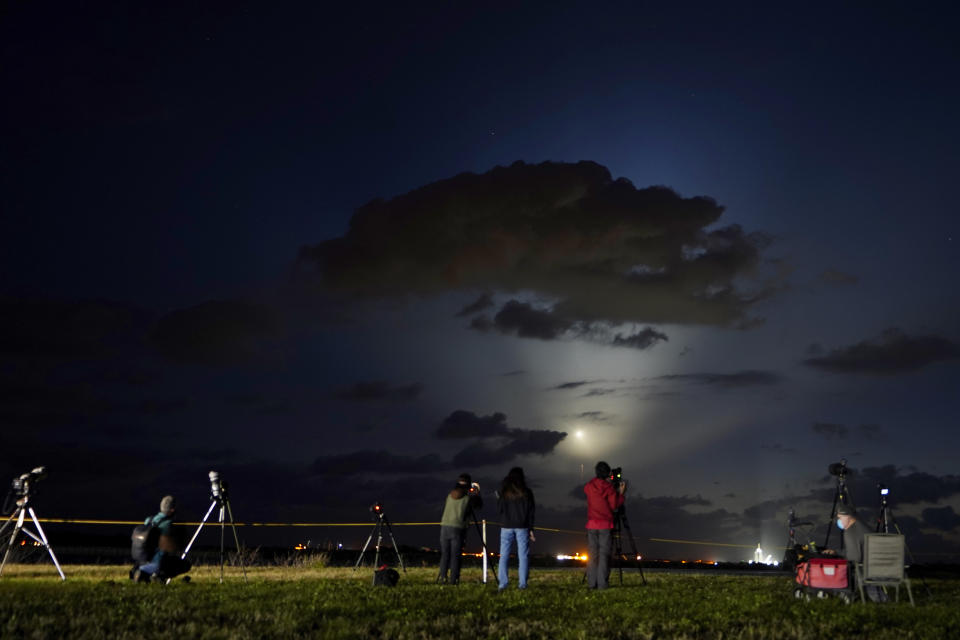 Photographers watch SpaceX Falcon 9 rocket with the Crew Dragon space capsule lift off from pad 39A at the Kennedy Space Center in Cape Canaveral, Fla., Friday, April 23, 2021. (AP Photo/Brynn Anderson)