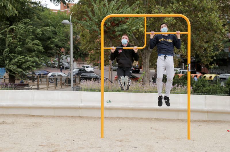 Dos jóvenes con mascarillas hacen ejercicio en un parque del barrio de Carabanchel de Madrid