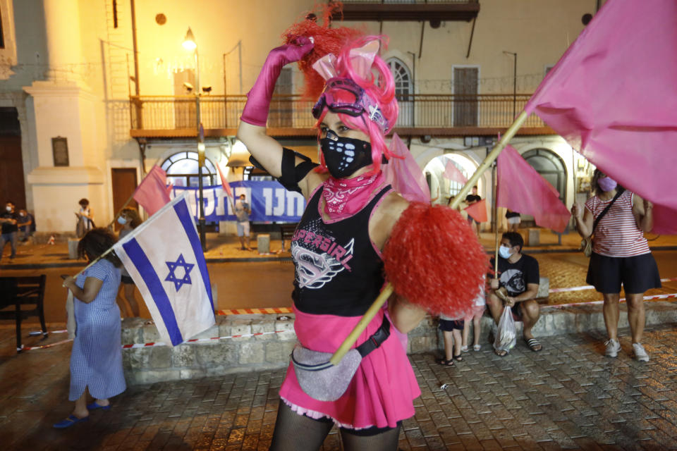 People chant slogans during a protest against Prime Minister Benjamin Netanyahu in Jaffa, Israel, Thursday, Oct. 8, 2020 during a nationwide lockdown to curb the spread of the coronavirus. The Israeli government has extended an emergency provision that bars public gatherings, including widespread protests against Netanyahu, for an additional week. (AP Photo/Ariel Schalit)