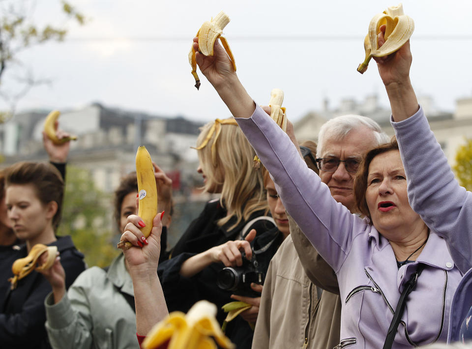 People with bananas demonstrate outside Warsaw's National Museum, Poland, Monday, April 29, 2019, to protest against what they call censorship, after authorities removed an artwork at the museum featuring the fruit, saying it was improper. (AP Photo/Czarek Sokolowski)