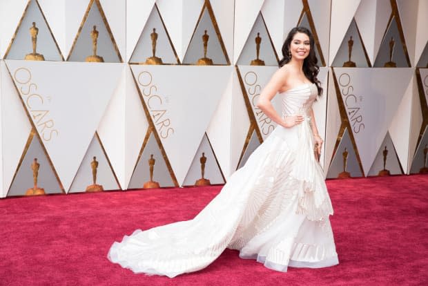 <p><em>Moana </em>actress Auli'i Cravalho shined in a white Rubin Singer gown at the 89th Oscars. The gown moved beautifully with a unique fan pattern with gold stitching. The 16-year-old changed into a simple red gown later to perform "How Far I'll Go" from the Disney animated film (which was nominated for Best Animated Feature) with <a href="https://parade.com/1219393/jessicasager/lin-manuel-miranda-net-worth/" rel="nofollow noopener" target="_blank" data-ylk="slk:Lin-Manuel Miranda;elm:context_link;itc:0;sec:content-canvas" class="link ">Lin-Manuel Miranda</a>.</p>