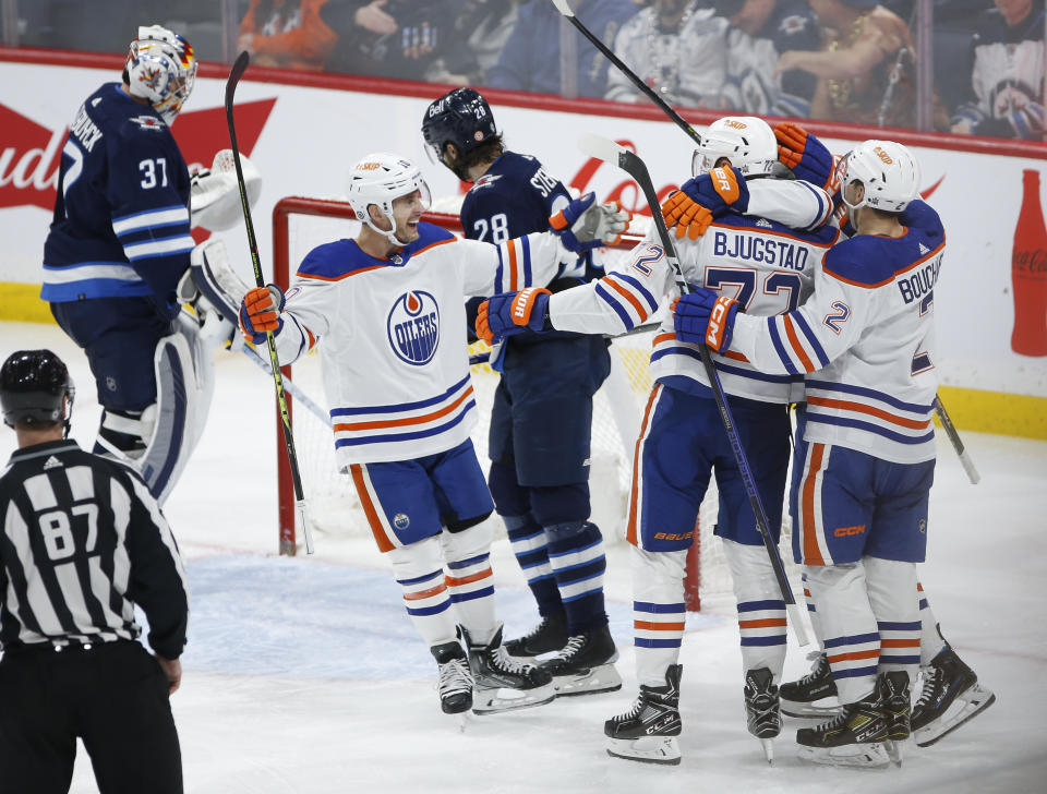 Edmonton Oilers' Derek Ryan (10), Nick Bjugstad (72) and Evan Bouchard (2) celebrate after Bjugstad's goal against the Winnipeg Jets during third-period NHL hockey game action in Winnipeg, Manitoba, Saturday, March 4, 2023. (John Woods/The Canadian Press via AP)