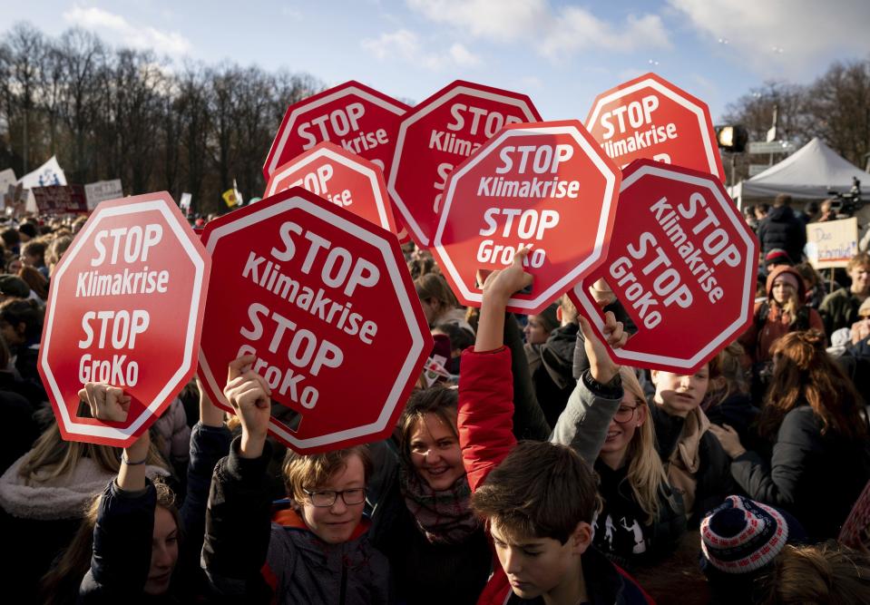 Young people attend a protest of the Fridays For Future movement in Berlin, Germany, Friday, Nov. 29, 2019. Environmentalists around the world are joining a global day of protests Friday, in a symbolic gesture to demand that governments act against climate change. The posters read: 'Stop climate crisis Stop GroKO (means the ruling Grand Coalition). (Kay Nietfeld/dpa via AP)