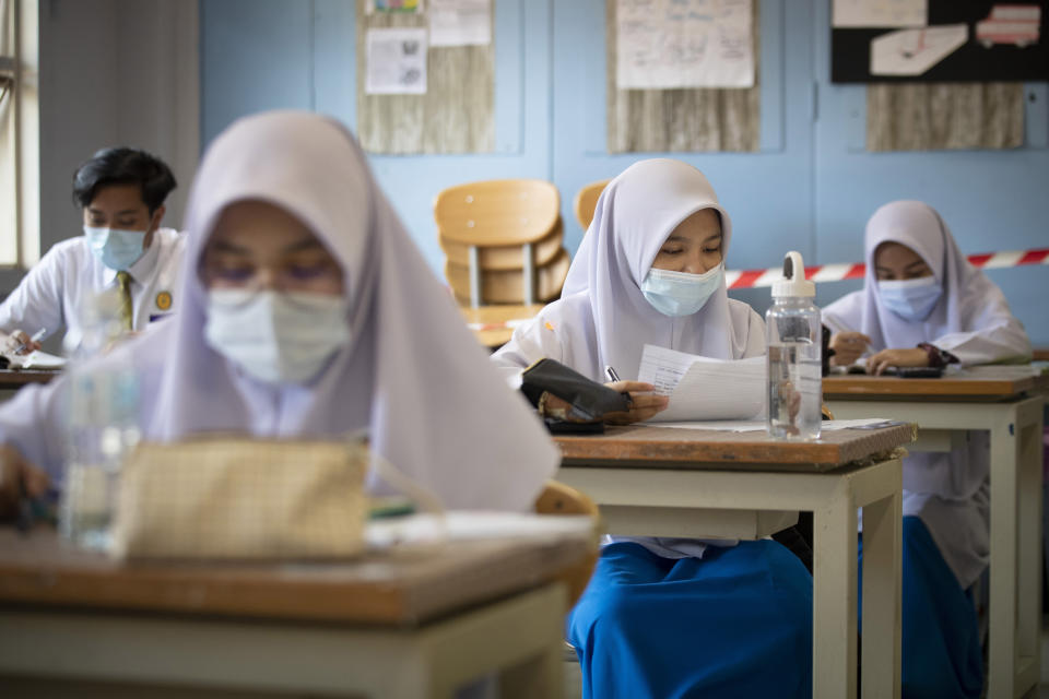 FILE - In this June 24, 2020, file photo, students wearing face masks and maintaining social distancing at a classroom during the first day of school reopening at a high school in Putrajaya, Malaysia. The United Nations advised Southeast Asian nations to tackle inequality and green their economies to build a more resilient and inclusive future as they strive to recover from the COVID-19 pandemic, according to the policy report released Thursday, July 30, 2020. (AP Photo/Vincent Thian, File)