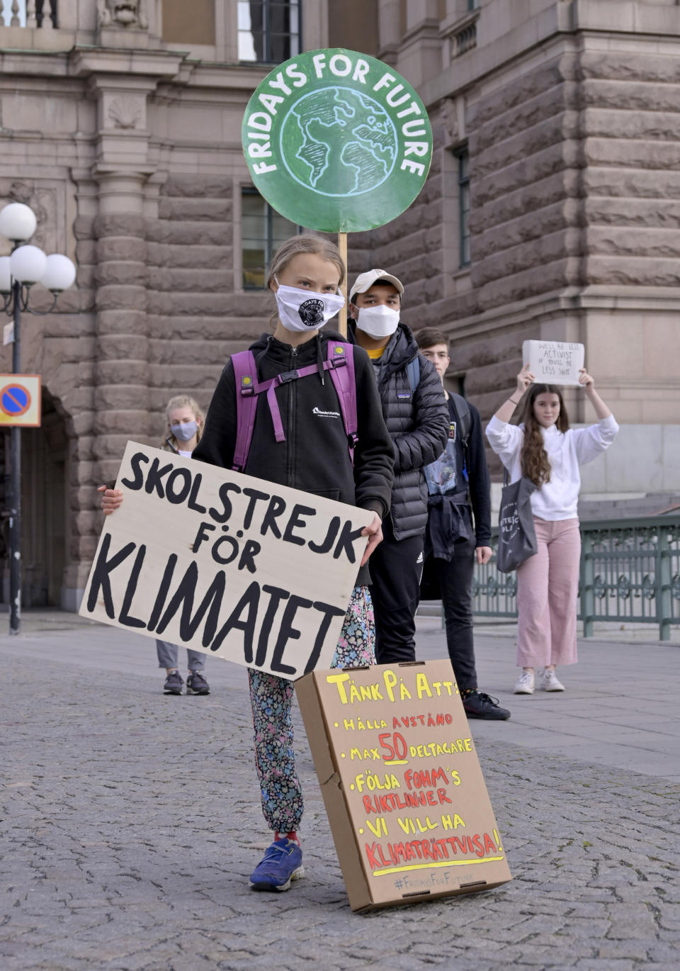 Swedish climate activist Greta Thunberg, center, holding a sign reading "School strike for Climate"and others protest in front of the Swedish Parliament Riksdagen in Stockholm Friday, Sept. 25, 2020. ( Janerik Henriksson/TT News Agency via AP)