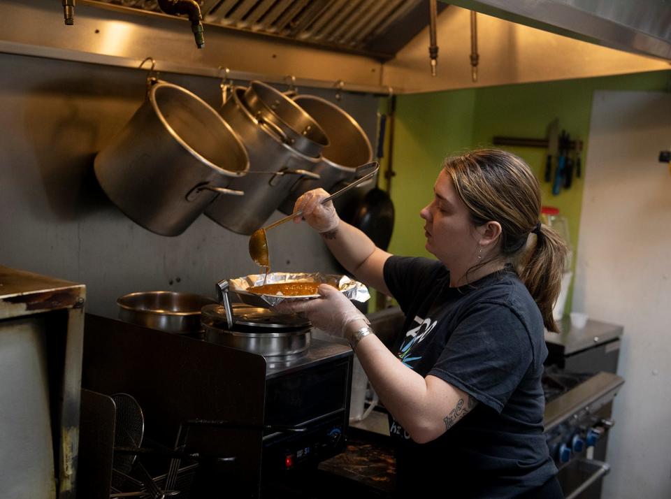 Taco Tontos manager Emma Lasko prepares an order of enchiladas.