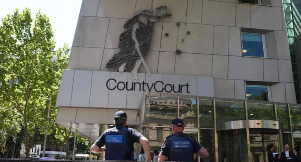 Police officers walk into Victoria County Court.