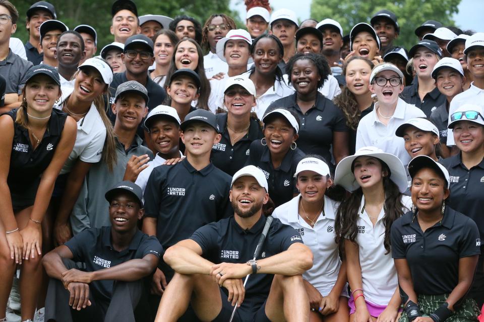 Stephen Curry poses for a group shot with Underrated Golf tour players on the South Course at Firestone Country Club in Akron.