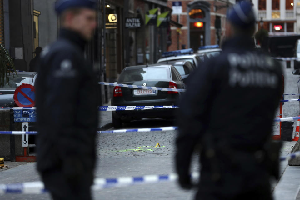 Police officers stand next to a cordoned off area where a policeman was stabbed in Brussels, early morning Tuesday, Nov. 20, 2018. A policeman was stabbed Tuesday by an assailant who was shot close to the Grand Place in Brussels' historic centre. (AP Photo/Francisco Seco)