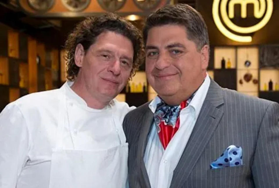 Marco Pierre White in chef's whites and Matt Preston in a grey pinstriped suit, red and blue cravat and blue spotted hanky in his pocket on Masterchef Australia.