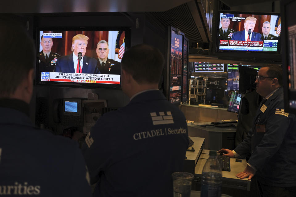 Traders pause to watch a televised speech by President Donald Trump as they work the floor of the New York Stock Exchange in New York, Wednesday, Jan. 8, 2020. (AP Photo/Seth Wenig)