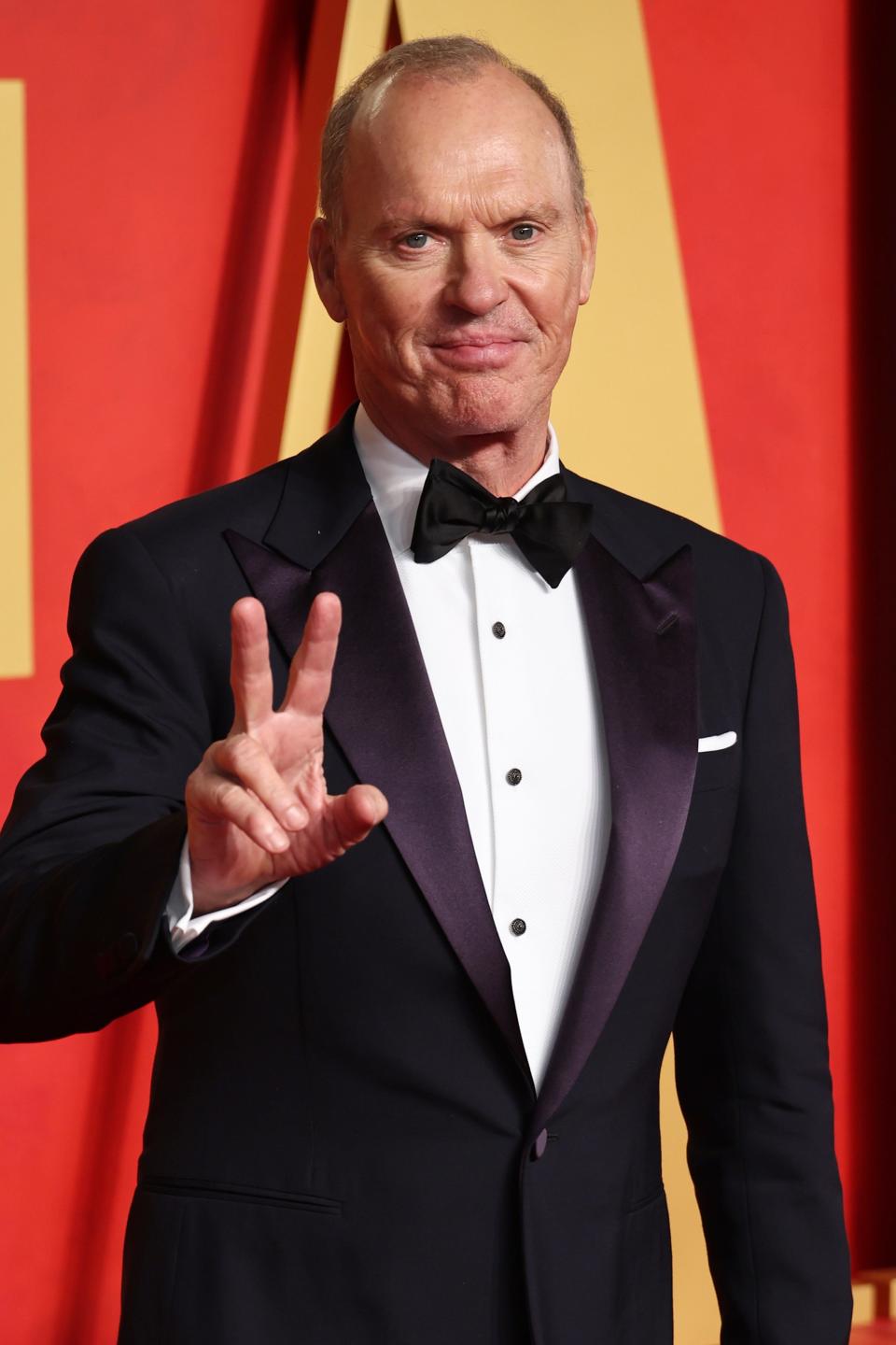 Closeup of Michael Keaton throwing the peace sign