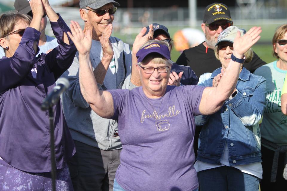 Judy Recker acknowledges spectators during a ceremony naming the Fowlerville track and field complex in her honor on Tuesday, May 9, 2023.