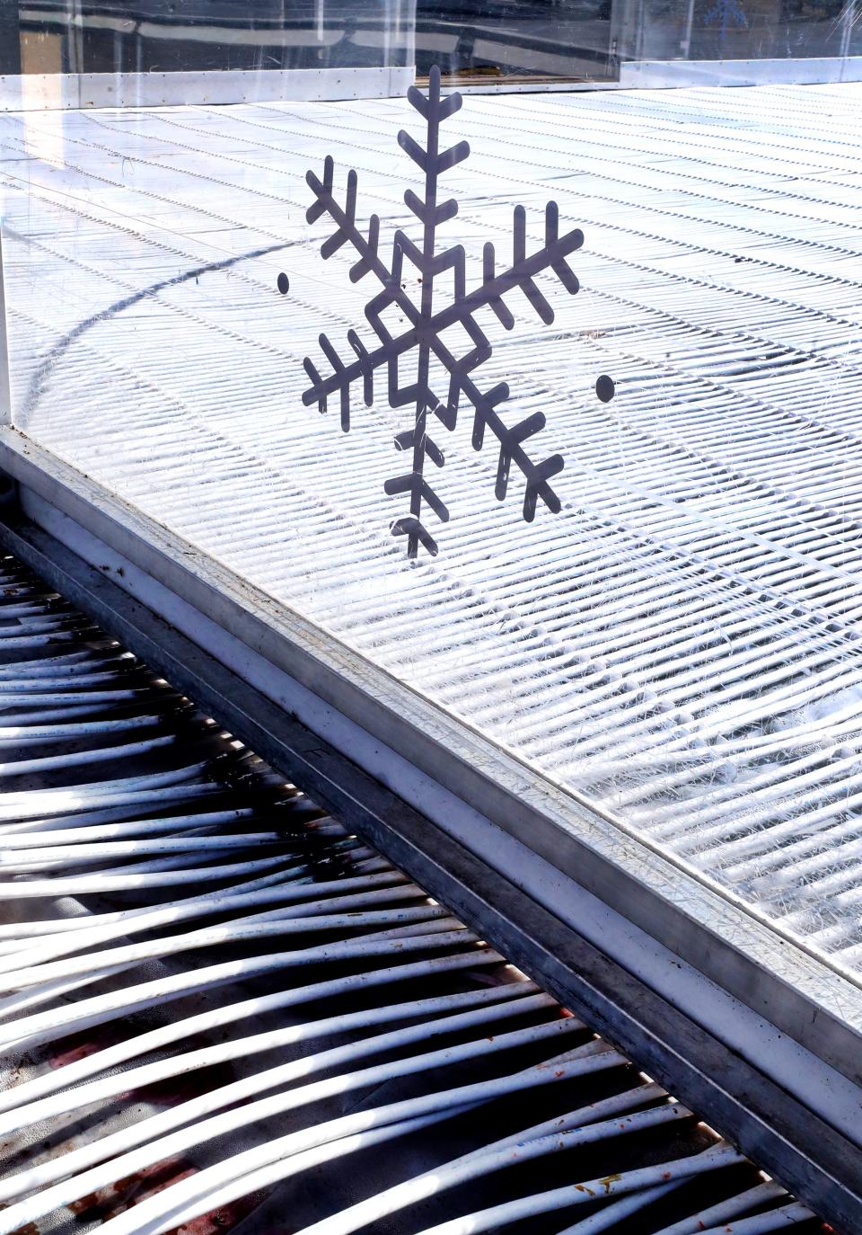 Snowflakes can be found on the walls of the ice rink being assembled for Winterfest 2022 at Fountains at Gateway, on Wednesday, Nov. 9, 2022. The tubes running on the bottom of the rink contain an antifreeze substance. Water will be added after the rink and platform is completed. 