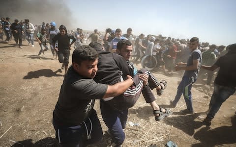 Palestinians carry an injured protestor during a demonstratoin near the Shuja'iyya neighborhood of Gaza City - Credit:  Anadolu