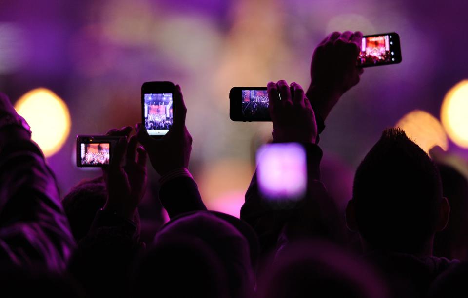 Fans take photos with their mobile phones during the VH1 "Divas Salute The Troops" show at the Marine Corps Air Station Miramar in San Diego, in this December 3, 2010, file photo. Snapchat, the mobile photo-sharing service beloved by teenagers and twenty-somethings, has raised another $50 million, according to a Securities and Exchange Commission filing made December 11, 2013. The funding brings the total raised by the two-year-old company to more than $123 million. REUTERS/K.C. Alfred/Files (UNITED STATES - Tags: ENTERTAINMENT SCIENCE TECHNOLOGY)