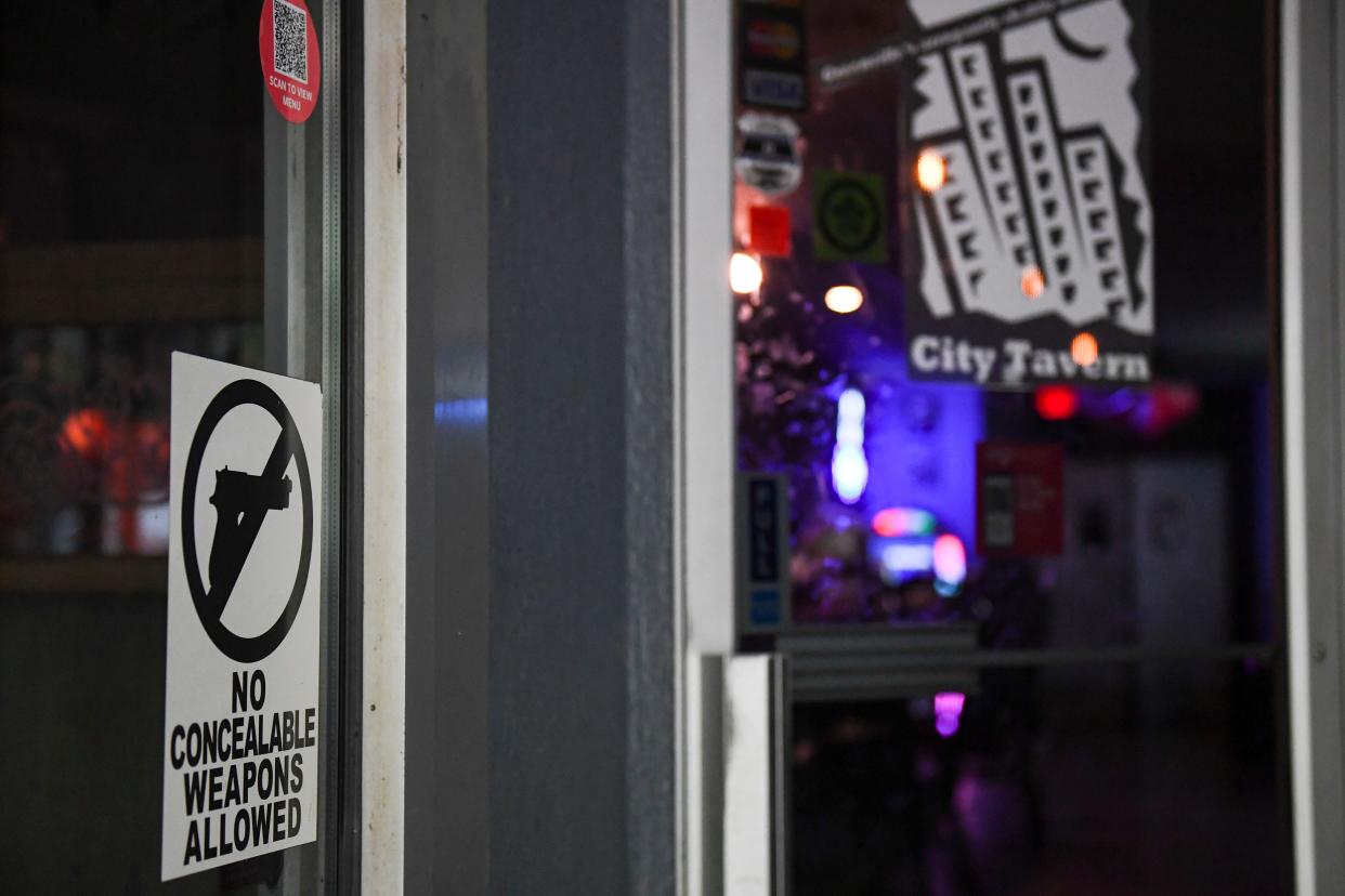 A "No concealable weapons" sign is seen in the doorway at City Tavern in downtown Greenville on Friday, May 3, 2024.