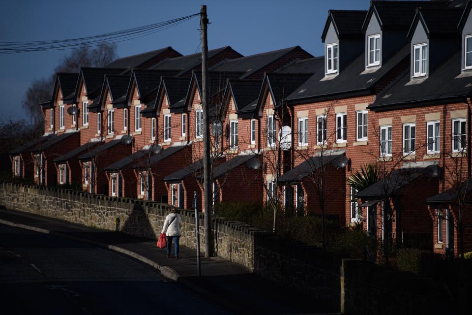 UK property: A woman walks past a row of houses in Wrexham town centre 