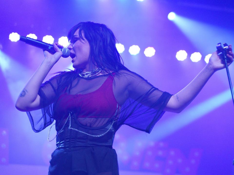 Music artist Upsahl sings into a microphone during a performance in Tempe, Arizona.