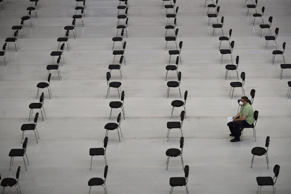 A man waits after receiving the Pfizer vaccine, during a COVID-19 vaccination campaign, in Pamplona, northern Spain, Tuesday, May 11, 2021. (AP Photo/Alvaro Barrientos)