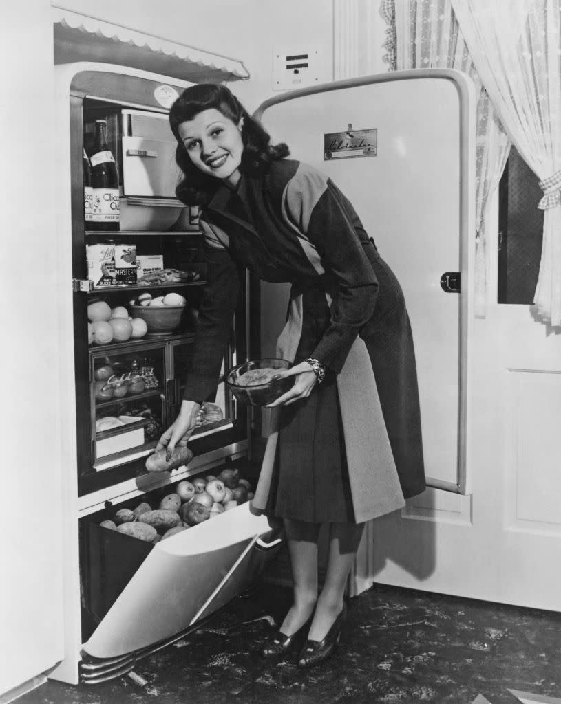 <p>The <em>Gilda </em>actress shows off a packed refrigerator and pulls a potato from the bottom drawer while making dinner in 1941. </p>