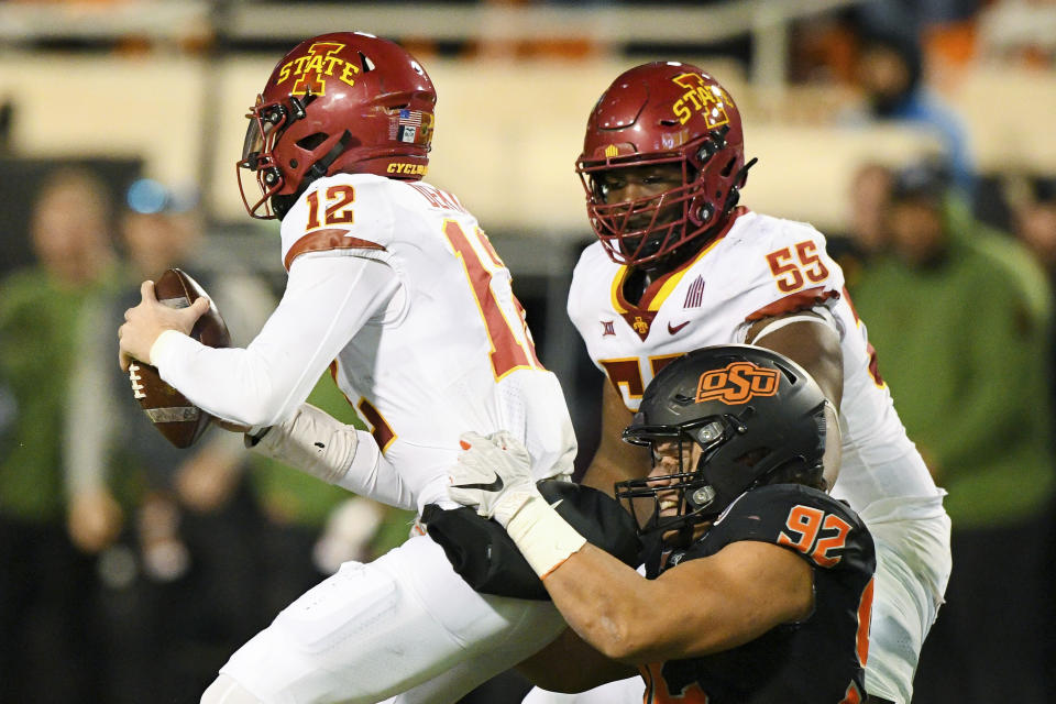 Iowa State offensive lineman Darrell Simmons Jr. (55) watches as Oklahoma State defensive end Nathan Latu (92) sacks Iowa State quarterback Hunter Dekkers (12) during the final minutes of an NCAA college football game Saturday, Nov. 12, 2022, in Stillwater, Okla. (AP Photo/Brody Schmidt)