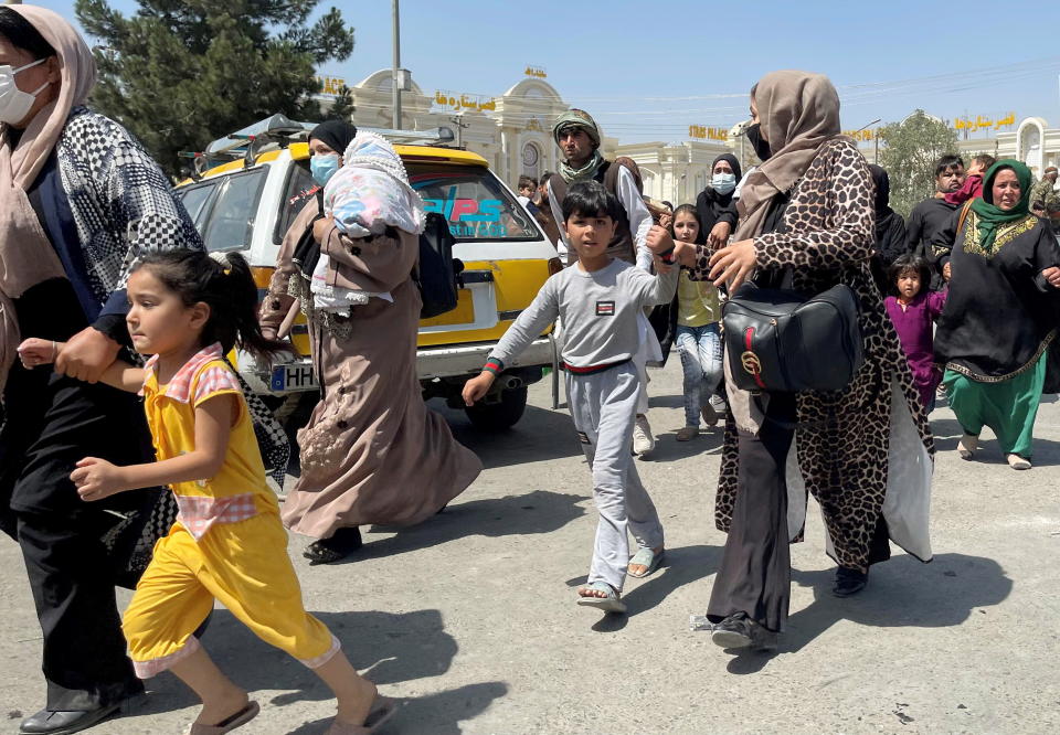 Women with their children try to get inside Hamid Karzai International Airport in Kabul, Afghanistan August 16, 2021. (Reuters)