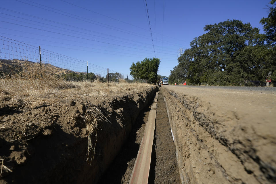 A Pacific Gas and Electric crew works on burying power lines in Vacaville, Calif., Wednesday, Oct. 11, 2023. PG&E wants to bury many of its power lines in areas threatened by wildfires. (AP Photo/Jeff Chiu)