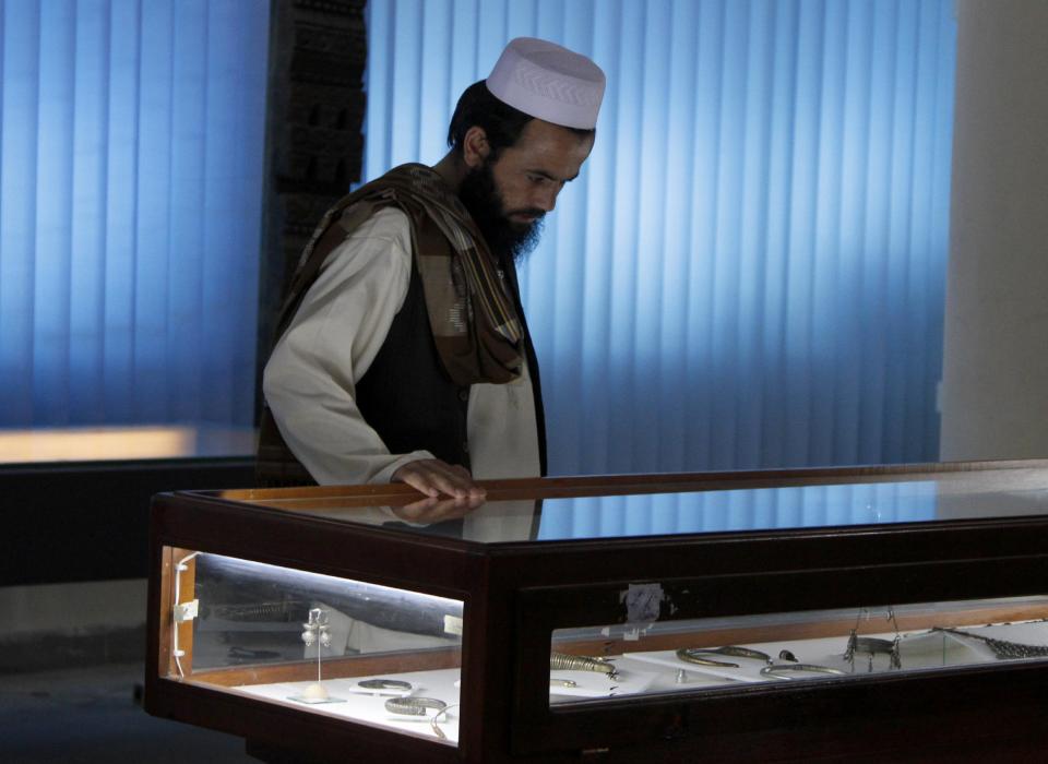 An Afghan man looks at artifacts at the National Museum in Kabul, Afghanistan, Friday, June, 28, 2013. Looters stole tens of thousands of artifacts from the National Museum of Afghanistan during the country's civil war in the 1990s, and then thousands more were destroyed by the Taliban when they took power. Now the museum is slowly coming back to life, helped by millions of dollars in U.S. and other foreign aid. Every day 300 to 400 visitors a day come to see the collections of sculptures, jewelry, coins and other artifacts dating from the Stone Age through the 20th century.(AP Photo/Ahmad Jamshid)