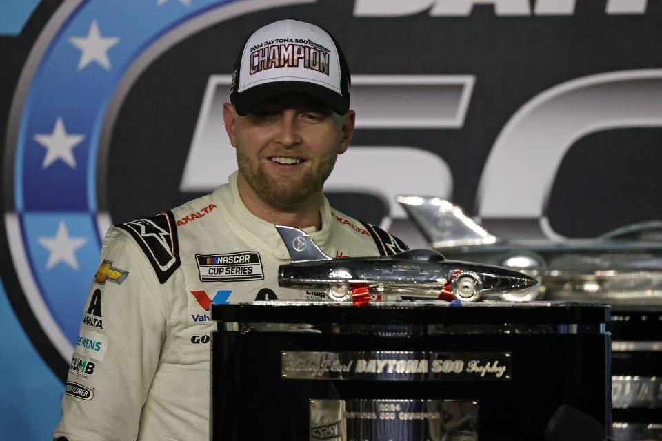 William Byron (24) poses with the Harley J. Earl Trophy after winning the 2024 Daytona 500.