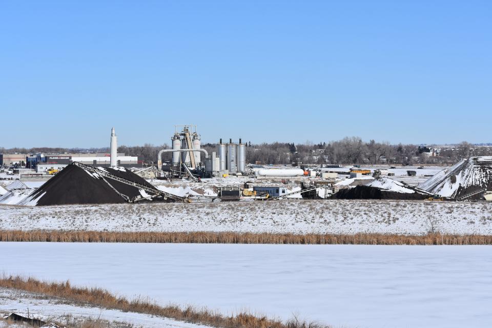 A frozen gravel pit pond lies in the foreground with the Connell Resources gravel operation in the background at the northeast corner of Kechter Road and Interstate 25 in Timnath, Colo., on Thursday, Feb. 16, 2023.