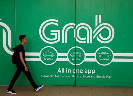 A man walks past a Grab office in Singapore March 26, 2018. REUTERS/Edgar Su