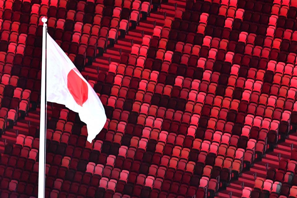 The Japanese flag wave above empty seats during the Opening Ceremony.