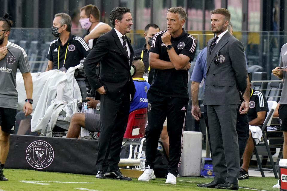 David Beckham, right, owner and president of soccer operations for Inter Miami, talks with coach Phil Neville, center, and David Gardner, left, before an MLS soccer match between Inter Miami and CF Montreal, Wednesday, May 12, 2021, in Fort Lauderdale, Fla. (AP Photo/Lynne Sladky)