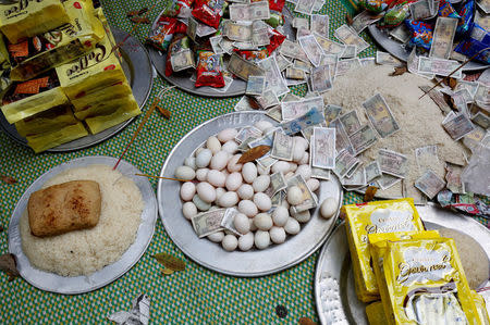 Money and food are prepared as an offering during a ritual at a Hau Dong ceremony at Lanh Giang temple in Ha Nam province, Vietnam, March 26, 2017. REUTERS/Kham