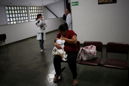 Jaqueline (C), 25, breastfeeds her five-month-old daughter Laura as a doctor (back) holds five-month-old Lucas during a medical test at the University of Sao Paulo (USP) in Sao Paulo, Brazil April 28, 2016. REUTERS/Nacho Doce