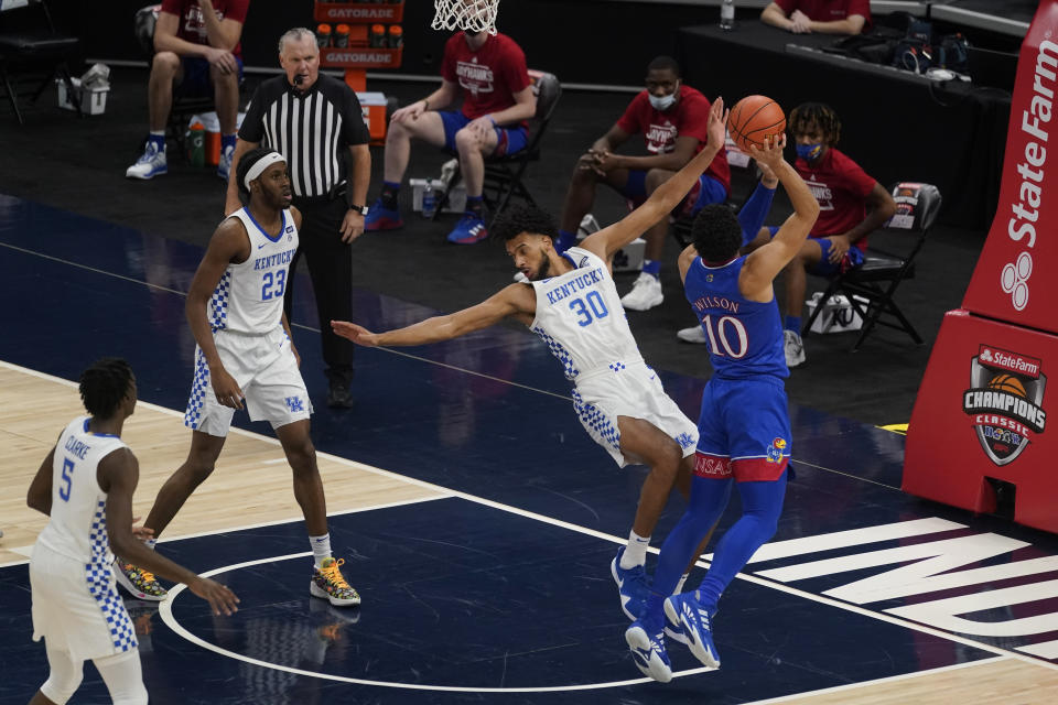 Kansas' Jalen Wilson (10) shoots next to Kentucky's Olivier Sarr (30) and is called for a foul during the second half of an NCAA college basketball game Tuesday, Dec. 1, 2020, in Indianapolis. (AP Photo/Darron Cummings)