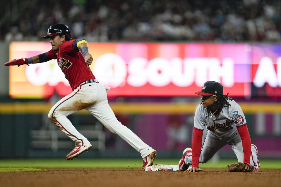 Atlanta Braves Nicky Lopez (15) runs to third past Washington Nationals shortstop CJ Abrams (5) on a hit by Atlanta Braves Eddie Rosario (8) during fifth inning of an baseball game, Friday, Sept. 29, 2023, in Atlanta. (AP Photo/Mike Stewart)