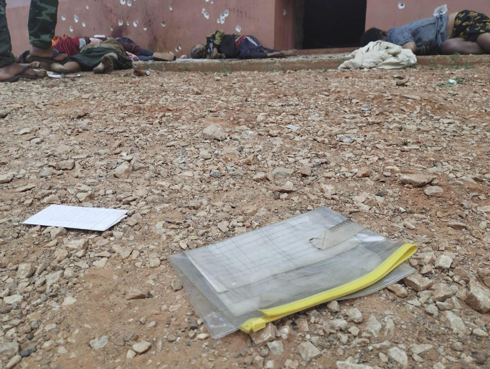 In this image provided by the Pa-Oh National Defense Force-Kham Koung, census forms inside a plastic envelope can be seen near bodies lying on the ground of a Buddhist monastery in Nam Nein village, Pinlaung township in Shan state, Myanmar on Sunday, March 12, 2023. Myanmar's military government has denied reports of a new mass killing of civilians by its troops, instead blaming pro-democracy resistance groups for the deaths of more than 20 people. (Pa-Oh National Defense Force-Kham Koung via AP)
