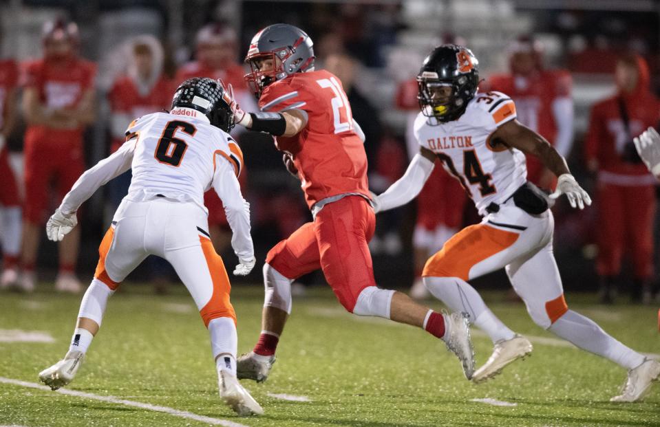 Jake Gill (center) stiff arms his way downfield as Owen Beatty and Jaden Schlabach close in.