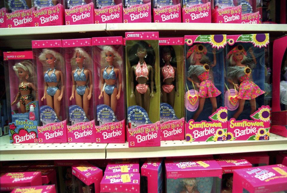 FILE - Barbie dolls line the shelves at a toy store in Torrance, Calif., Dec. 14, 1995. The color pink has long been associated with the Barbie brand — she even has her own Pantone color. But even though Barbie was first released in 1959, Mattel didn't star featuring predominantly pink packaging until the 1970s, said Kim Culmone, Mattel's senior vice president and global head of Barbie and fashion dolls design. (AP Photo/Eric Draper, File)