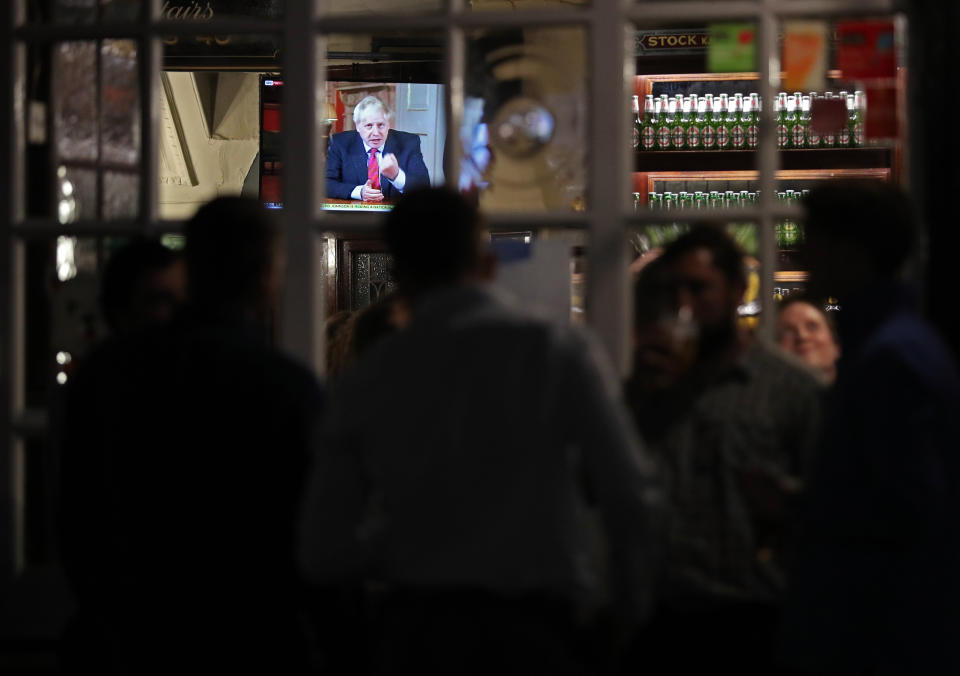 Customers at the Westminster Arms pub in London watch Prime Minister Boris Johnson address the nation regarding new coronavirus restrictions, including office staff working from home, the wider use of face masks and a 10pm curfew on pubs and restaurants.